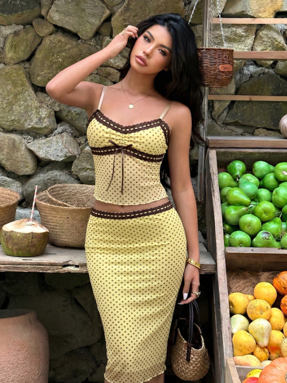 Outfit nữ đi du lịch từ quần áo nữ FoureLabel với set áo hai dây và chân váy chấm bi màu vàng thanh lịch.